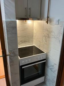 a stove top oven in a kitchen with marble walls at Relax Apratman in Gornji Milanovac