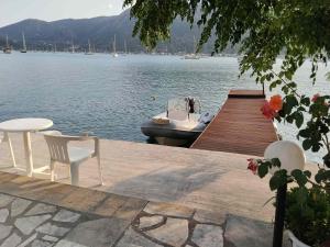 a dock with chairs and a boat on the water at Geni Bay 2 in Lefkada