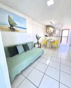 a living room with a green couch and a kitchen at Beach Class Exclusive in Fortaleza