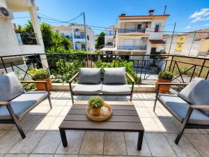 a patio with two chairs and a table on a balcony at Anris & Dianas Dom - In a quiet part of the center in Kallithea Halkidikis
