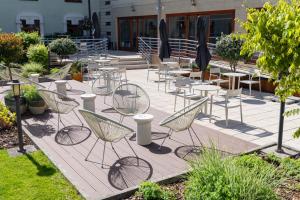 a group of chairs and tables on a patio at Hotel Három Gúnár in Kecskemét