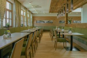 a dining room with long tables and chairs at Hotel Metzgerwirt in Sankt Veit im Pongau