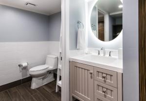a bathroom with a toilet, sink and mirror at Banana Bay Resort & Marina in Marathon