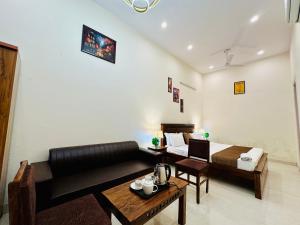 a living room with a couch and a bed and a table at Hotel Oxygen Stay in Noida