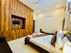 a bedroom with two beds and a tv on a wall at Hotel Oxygen Stay in Noida