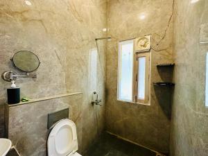 a bathroom with a toilet and a window at Hotel Oxygen Stay in Noida