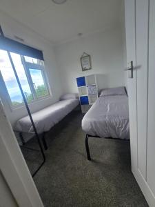 a bedroom with two beds and a window at 43 sea valley in Bideford