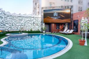 a large swimming pool in front of a building at Majestic Premier Hotel Burdubai in Dubai