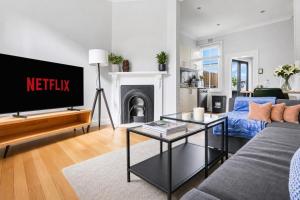 a living room with a tv and a couch at 2 Bedroom House Woolloomooloo in Sydney