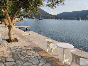 a table and chairs next to a body of water at Geni Bay in Yénion