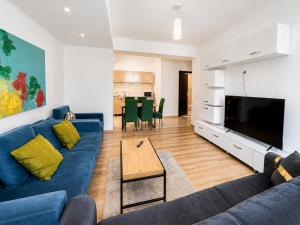 a living room with a blue couch and a television at MAMAIA SAMMERLAND APARTAMENT 3 camere in Mamaia
