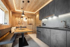 a kitchen with a wooden ceiling and a wooden table at Col Dala Vara in San Cassiano