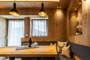 a dining room with a wooden table and two lights at Col Dala Vara in San Cassiano