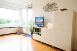 a living room with a tv on a white cabinet at Ferienwohnung Seeland in Niendorf
