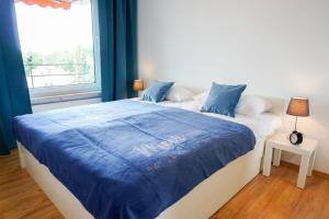 a bedroom with a large bed with a blue blanket at Ferienwohnung Seeland in Niendorf +18 photos