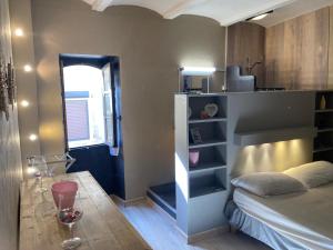 a bedroom with a bed and a table and a window at La petite maison in Lagorce