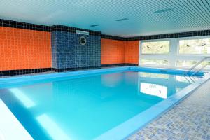 a large swimming pool with orange walls and blue tiles at Ferienwohnung Seeland in Niendorf