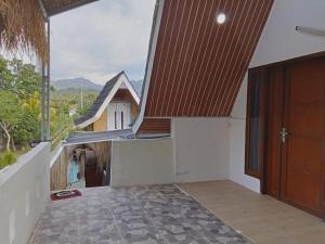a room with a door and a view of a house at Galuh Hostel Lombok in Pawenang