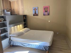 a bedroom with a bed and two pictures on the wall at La petite maison in Lagorce +14 photos
