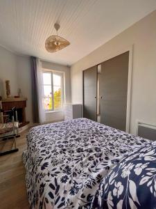 a bedroom with a bed with a black and white comforter at logement de charme vue mer in Binic