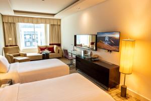 a hotel room with two beds and a flat screen tv at Majestic Premier Hotel Burdubai in Dubai