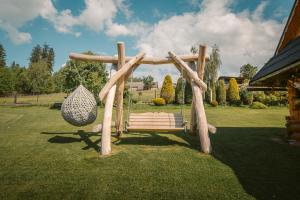 a park bench with a swing in a yard at Pokoje u Borzana in Biały Dunajec +76 photos