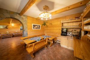 a dining room with wooden walls and wooden tables and benches at Pokoje u Borzana in Biały Dunajec