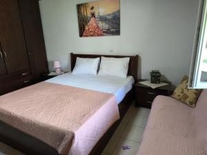 a bedroom with two beds and a painting on the wall at Maria's House in Keramoti