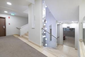 a hallway of a building with stairs and a door at Hotel Három Gúnár in Kecskemét