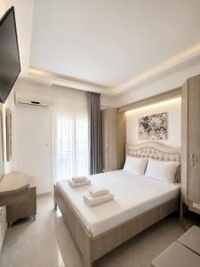 a bedroom with a large bed and a television at Myrto Rooms in Pefkochori