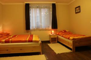 a bedroom with two beds and a window at Furmint Vendégház in Tállya +23 photos