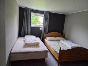 two beds in a small room with a window at Sjarmerende hus i havgapet i Selje in Salt