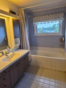 a bathroom with a sink and a tub and a window at Sjarmerende hus i havgapet i Selje in Salt +15 photos