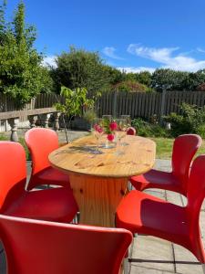 a wooden table with red chairs and wine glasses at Ashgrove, Kinsale in Kinsale