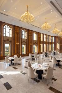 a dining room with tables and chairs and chandeliers at Blueworld Castles in Kānpur