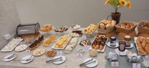 a table filled with different types of pastries and desserts at Uberlândia Suítes Hotel in Uberlândia