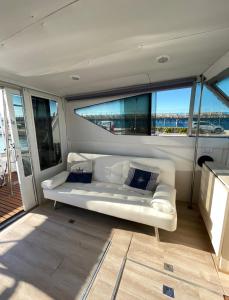 a white couch sitting in a room with windows at BED&BOAT boatandholiday in Fano