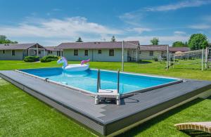 a pool with a swan float in a yard at Domki letniskowe Ranczo in Darłowo