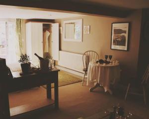 uma sala de estar com uma mesa e um piano em Glanmor Garden Apartment em Swansea