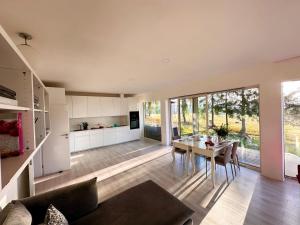 a living room with a table and a kitchen at ORNI House in Hazlov
