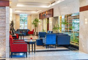 a lobby with blue and red chairs and tables at Xperience Sea Breeze Resort in Sharm El Sheikh
