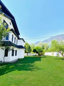 a house with a large yard with green grass at Rahat Resort in Srinagar