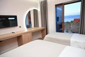 a hotel room with two beds and a flat screen tv at Kompleksi LYHNIDAS in Pogradec +54 photos