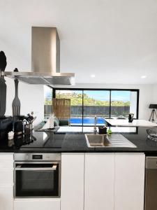 a kitchen with a sink and a stove top oven at Villa Bavaria B in Ponta do Sol