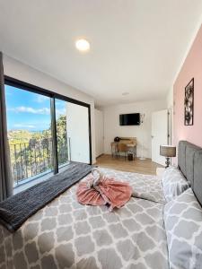a bedroom with a large bed and a large window at Villa Bavaria B in Ponta do Sol