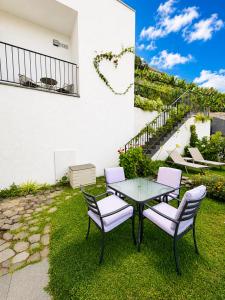 a patio with a table and chairs on the grass at Villa Bavaria B in Ponta do Sol