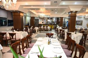 a dining room with white tables and chairs at Kompleksi LYHNIDAS in Pogradec