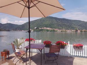 a table and chairs with an umbrella in front of a lake at Jezero in Potokovići