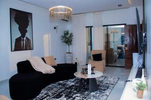 a living room with a black couch and a table at Dream Nest in Benin City
