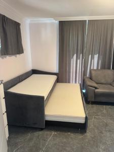 two beds in a room with a couch and a chair at Ferienwohnung Otterberg in Otterberg